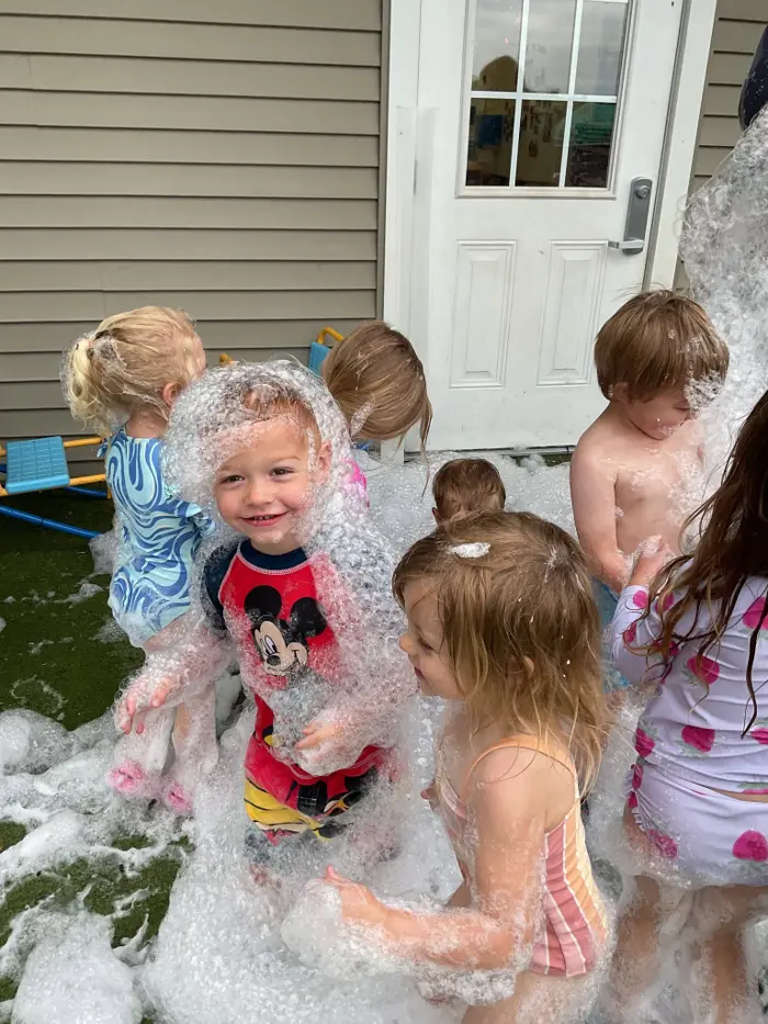 Children playing together with bubbles outdoors